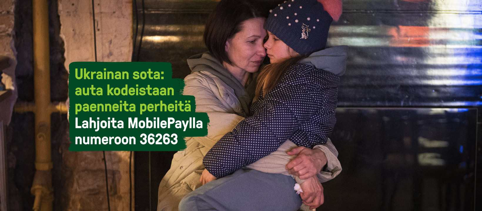Nainen kantaa sylissää lasta. Ukrainan sota: auta kodeistaan paenneita perheitä. Lahjoita MobilePaylla 36263
