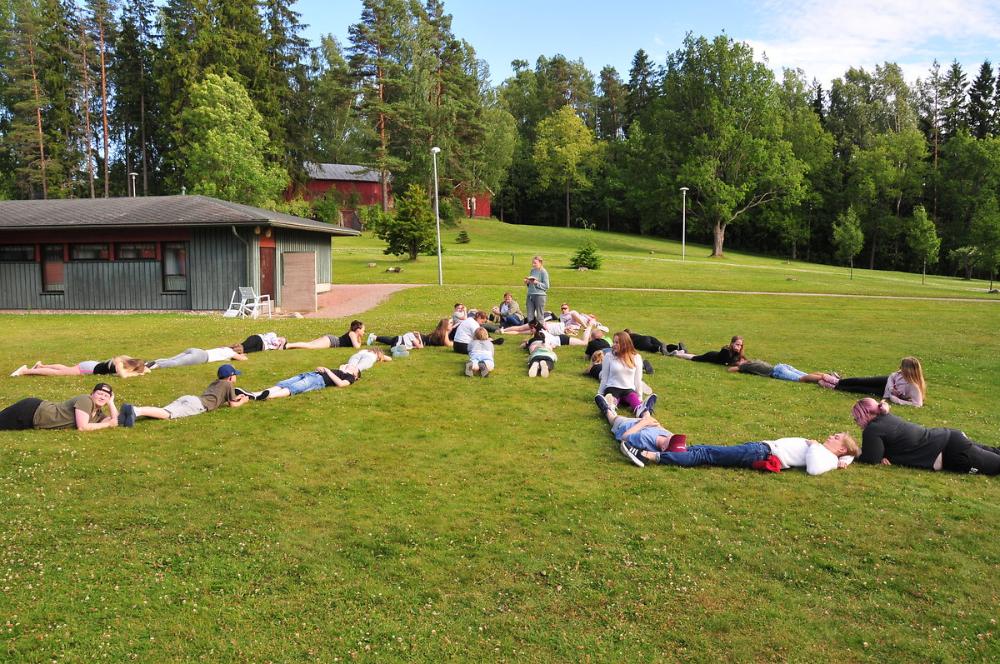 Ihmisiä makaamassa nurmella kuviossa