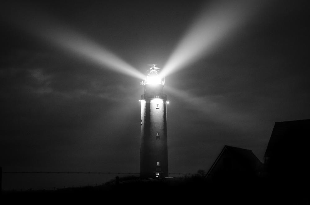 Mustavalkoinen kuva majakasta, josta loistaa valoa. Linkki Musailuiltapäivä satamassa -välilehdelle.