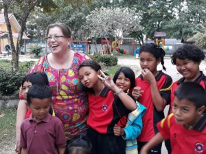 Kirsi Salmela thaimaalaisten lasten ympäröimänä.
