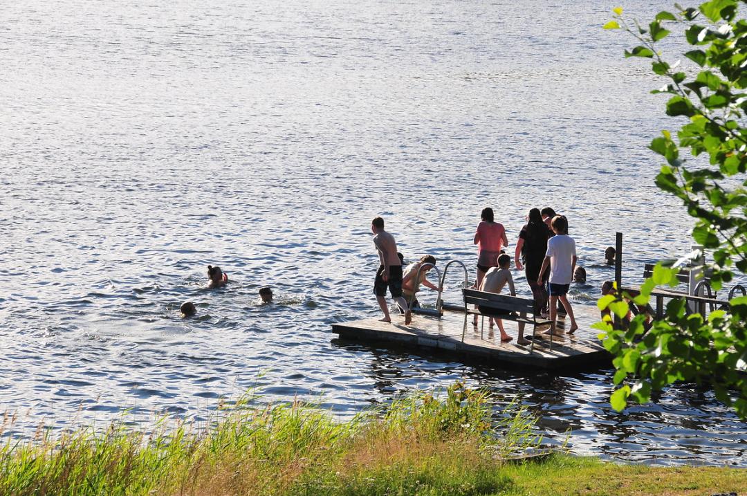 Ihmisiä laiturilla uimassa